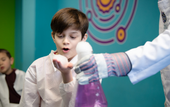 A kid wowed by a dry ice experiment.